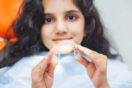 A beautiful girl showing her Inviable Invisalign braces.