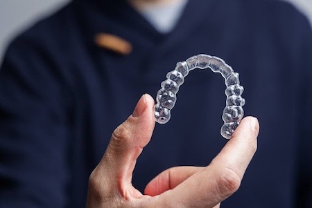 A man showing his Invisalign clear aligners.