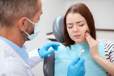 A female patient is getting emergency dental care.