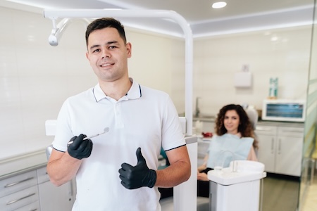 A dentist at his dental office examining and getting his patient ready for the laser gum disease treatment.