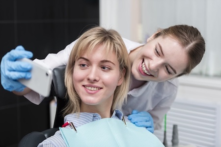 A happy dentist with her beautiful, smiling patient.