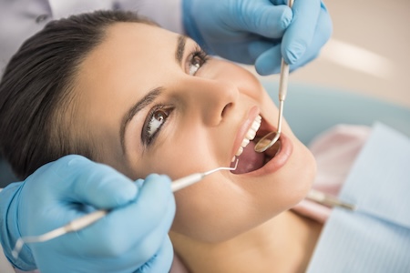 An endodontist examining her female patient.