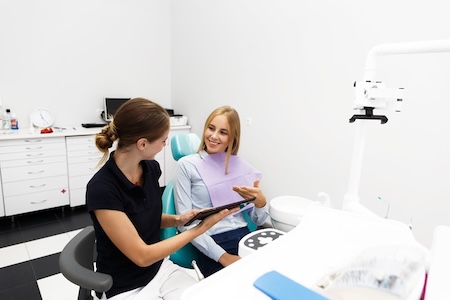 A female dentist consulting with her patient about wisdom teeth removal.