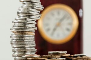 Coins stacked with clock in background