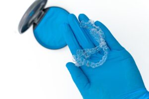 Dental aligner in blue gloved hand