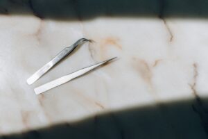 Tweezers on marble surface in sunlight