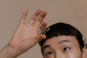 Person holding clear puzzle piece