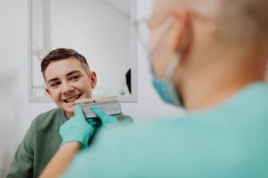 Dentist compares dental shade with patient