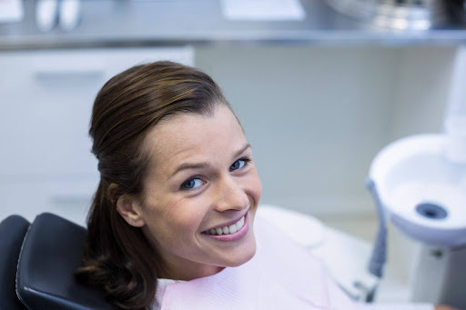 Happy female dental patient smiling during chairside dental consultation for full mouth reconstruction near Portland, Oregon.