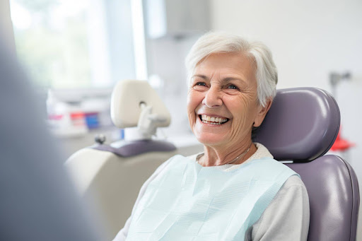 Senior female patient smiling comfortably in dental chair during consultation at modern dental clinic.